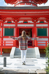 Woman enjoying nature walking in Japanese Garden with red pagoda