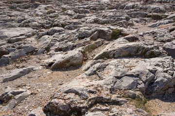 Natural rocky ground on a sunny day.  Horizontal framing, nobody