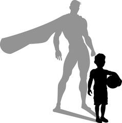 A superhero child or kid boy revealed by his shadow silhouette as a super hero in a cape.