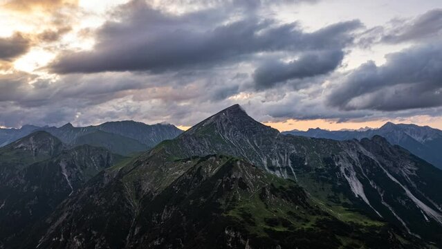 time lapse of a drone moving towards a mountain in dramatic evening light