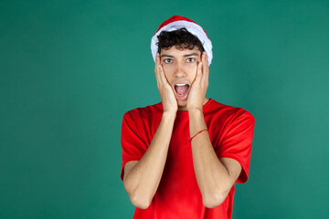 Chico sorprendido por navidad. Hombre vestido de papa noel. Hombre de rojo y fondo vende.