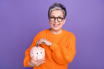 Photo portrait of middle age model businesswoman wear orange trendy shirt put money piggy bank...