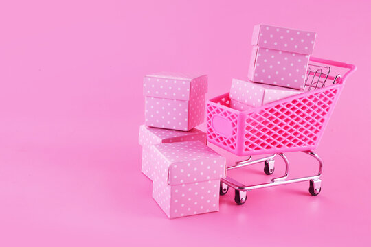 Pink friday concept. Online shopping.. Full shopping cart with presents. - Powered by Adobe