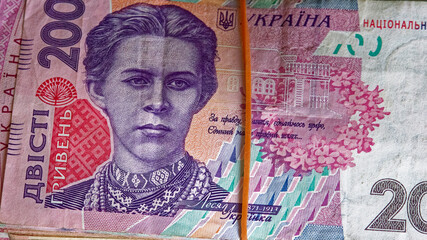 A stack of Ukrainian hryvnia banknotes, neatly bound with a rubber band. A bundle of Ukrainian money tied with an elastic band. Ukrainian hryvnia in denomination of 200. A bundle of banknotes.