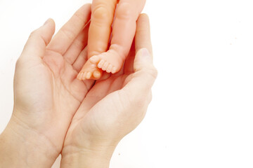 World Prematurity Day on 17th November. Woman hand with a baby feet . Motherhood and care.