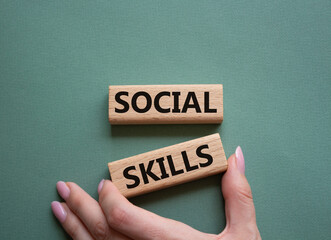 Social skills symbol. Wooden blocks with words Social skills Beautiful grey green background. Businessman hand. Business and Social skills concept. Copy space.