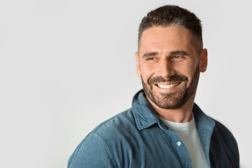 Obraz premium Middle aged guy looking aside over white studio backdrop