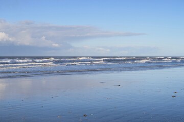 Wellen brechen am Strand der holländischen Nordseeinsel Schiermonnikoog an einem stürmischen Herbsttag.