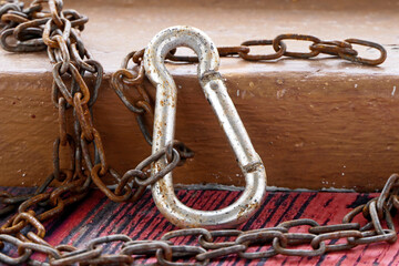 old rusty chain and carabiner on wooden background