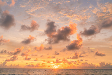 Sunset over the water with clouds against the sunlight on the Andaman Sea, Patong, Phuket, Thailand.