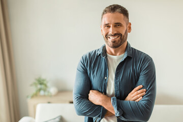 Cheerful middle aged man standing amidst modern living room