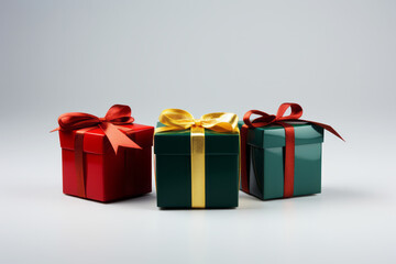 Obraz premium Three festive present boxes with ribbon and bow on light grey background. Winter holiday concept