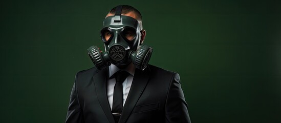 A man in a somber business attire holding onto an aged gas mask strangles himself portrayed against a backdrop of deep green isolation - obrazy, fototapety, plakaty