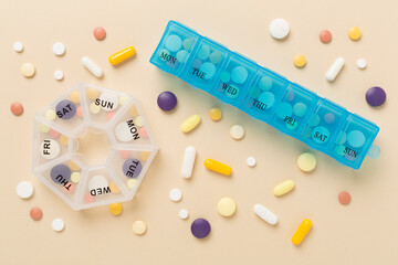 Daily pill boxes with medications on color background, top view