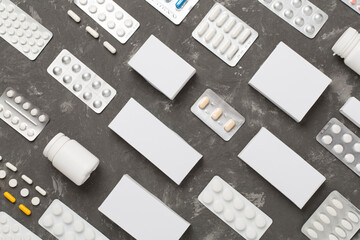 Flat lay with different pills in blister packaging and boxes and on concrete background