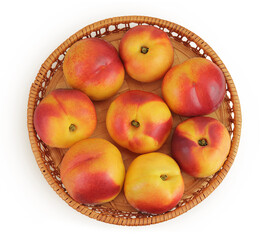 Ripe nectarine fruit in a wicker basket isolated on white background. Top view. Flat lay