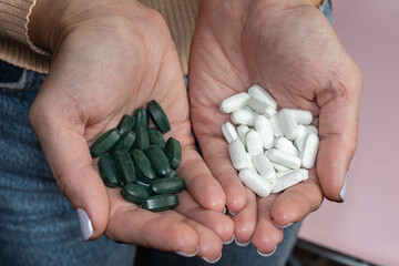 Woman holding pills in her hands. Drugs use for treatment the disease.