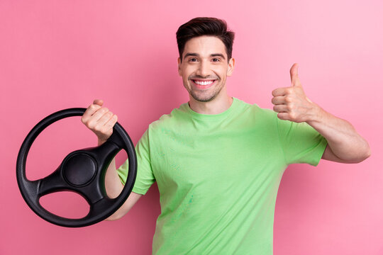 Photo of young smiling happy man thumb up rate high quality toyota car brand comfortable steering wheel isolated on pink color background
