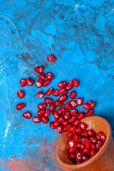 Several ripe pomegranate fruits and an open pomegranate, pomegranate on table, top view, dark...