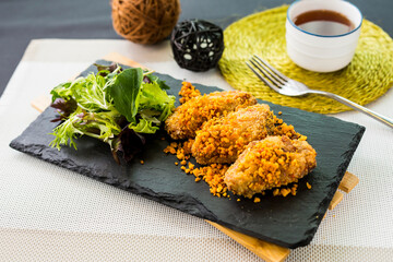 Typhoon Shelter Chicken Wing with Salad served on cutting board isolated on napkin side view of...