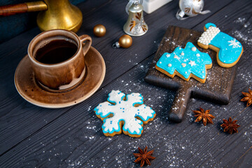 Traditional beautiful glazed gingerbread cookies and a cup of coffee on a wooden table. Christmas mood.