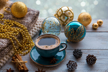 Christmas mood, holiday atmosphere. A cup of coffee, Christmas tree golden and turquoise balls,...