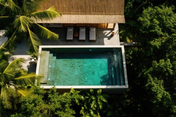 Top view of the hotel with pool and sun loungers in the rainforest.