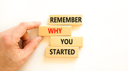 Remember why you started symbol. Concept word Remember why you started on wooden block. Beautiful white table white background. Businessman hand. Business remember why you started concept. Copy space.