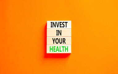 Invest in your health symbol. Concept word Invest in your health on beautiful wooden block. Beautiful orange table orange background. Invest in your health concept. Copy space.