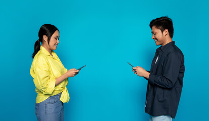 Smile asian couple in casual typing by smartphone, enjoy good news, chatting