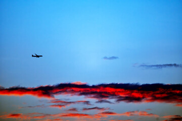 Commercial plane flying in the sunset
