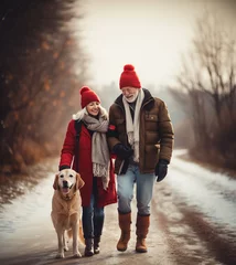 Foto op Aluminium Loving family walking with their golden retriever dog on a snowy country road. Smiling woman and older man wearing red Christmas hats, taking a walk on a calm winter day. © Studio Light & Shade