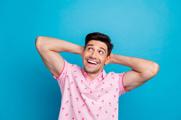 Fototapeta premium Photo of cheerful minded person arms behind head look empty space imagine isolated on blue color background