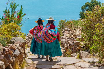 Peruvian indigenous Quechua women in traditional clothes on Taquile Island, Titicaca Lake, Peru. - obrazy, fototapety, plakaty