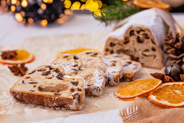 Christmas stollen on wooden background. Traditional christmas german dessert cut into pieces. Cake with nuts, raisins with marzipan and dried fruit on cutting board. baking for xmas