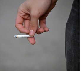 Man's hand holding a cigarette butt