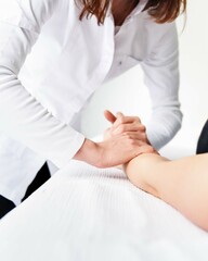 Plan raproché d'une ostéopathe massant la main d'un patient.