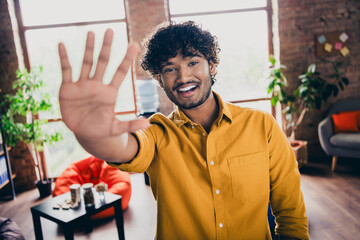 Photo portrait of attractive young man wear yellow shirt wave hand hello high five colleague say...