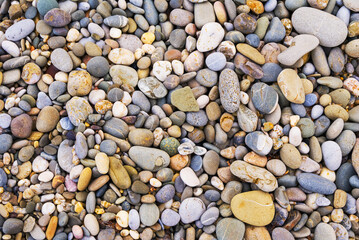 closeup heap of marine pebbles on sea coast, outdoor natural background