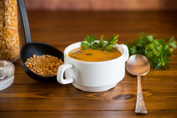 Cooked dried pea puree soup with mushrooms in a bowl .