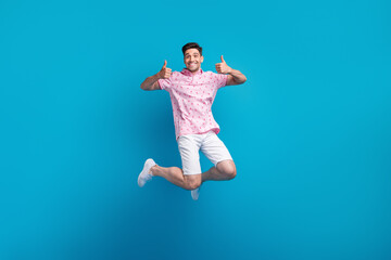 Full length photo of excited sporty person jumping hands fingers demonstrate thumb up isolated on...
