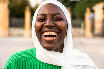 Portrait of beautiful african muslim woman in hijab smiling at camera outside