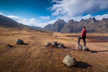 A man standing over rocks watching the land, enjoying the view of the beautiful epic landscape...