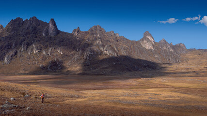Lonely peruvian peasant lost in a big landscape on the hight lands rocky ambient, dry season, blue...