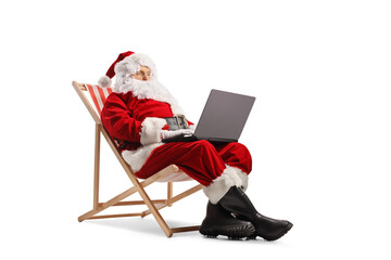 Santa claus and sitting on a deck chair and using a laptop computer