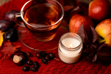 Cup of tea, candle, autumn fruits on the table. Autumn Evening Mood