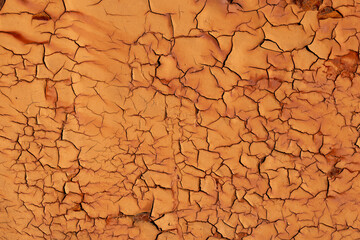 Cracked surface texture. The brown paint on the metal surface was cracked and rusty from age.