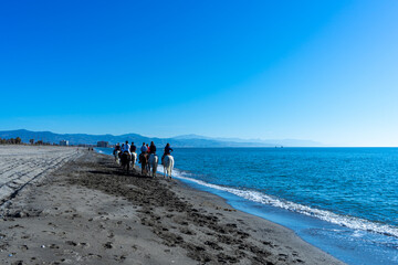 Riders on Mediterranean Sea at sunrise, Costa del Sol in Malaga, Spain