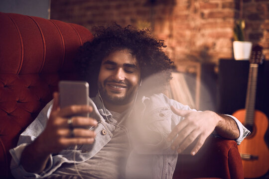 Man enjoying music and browsing his phone at the bar