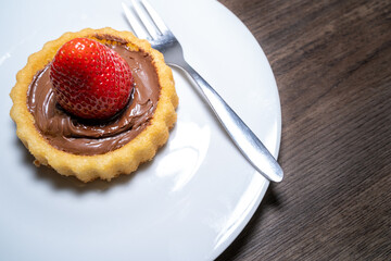Small cake with a strawberry and chocolate cream